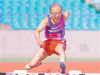 丁明在2026中国田径大师赛80—84岁组80米栏项目中跨栏。受访者供图 丁明在2026中国田径大师赛80—84岁组80米栏项目中跨栏。受访者供图