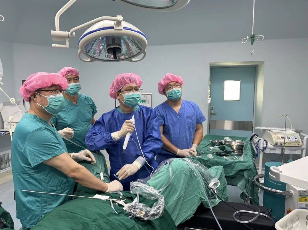 闵振宇（左三）在手术中操作输尿管软镜，并为本地医生示范上尿路复杂结石的微创处理技巧。