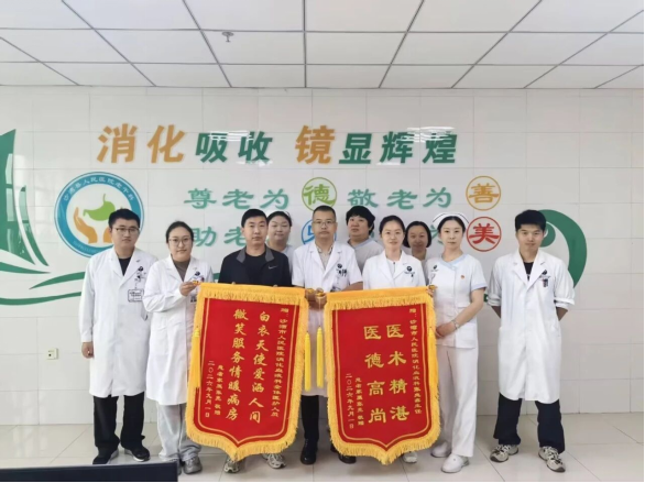 黄腾（右四）与赠送锦旗的患者及其他医务人员合影。