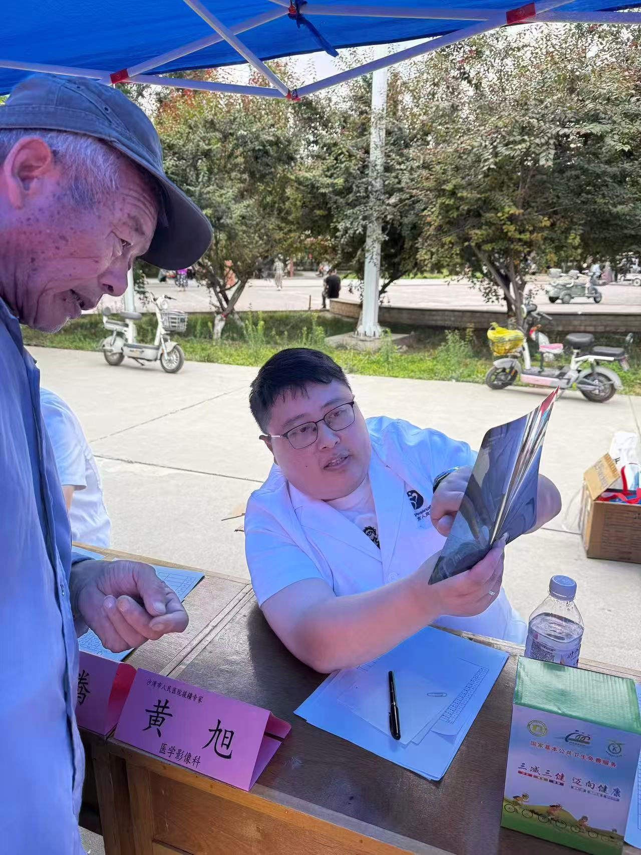 黄旭参加老沙湾镇义诊，为村民诊疗。